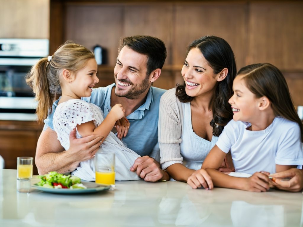 Servicio técnico de reparación cerca de ti Familia sonriente en la cocina, compartiendo un momento juntos con comida y bebida.